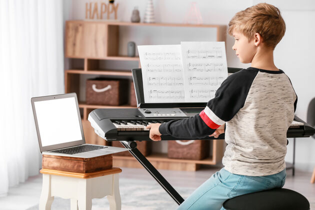 电小男孩在家在线上音乐课课程笔记本电脑音乐会