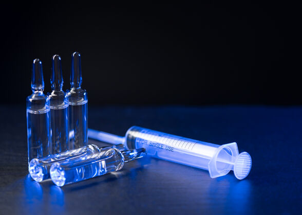 设备用于注射和注射器的药瓶和安瓿放在有复印空间的深色光滑桌子上流感药品剂量