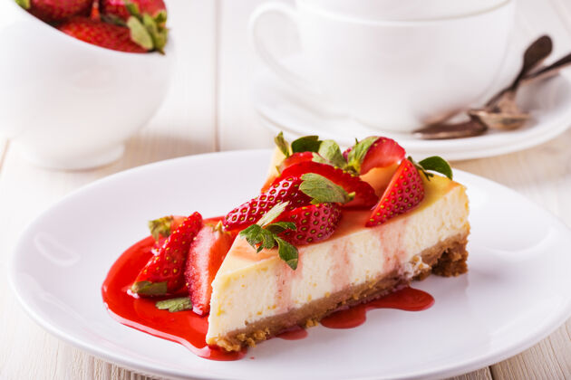 营养美味的自制芝士蛋糕和草莓放在白色的木桌上美味糕点小吃