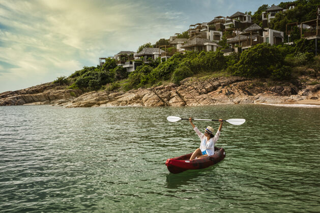 风景一位妇女划着皮划艇去探索平静的热带海湾 那里有石灰岩山脉马尔代夫泰国苏梅村岛船海湾石灰石