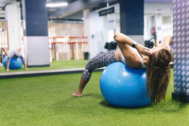 健身房在塑料球上做体操的女人姿势运动年轻