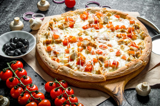 顶视图黑木桌上有鸡肉和西红柿的香喷喷的披萨橄榄奶酪深色的
