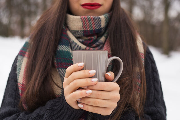 饮料美丽快乐微笑的女人拿着一个杯子在冬天的大街上时尚旅行咖啡