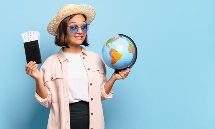 游客年轻漂亮的旅行家女人拿着世界地图旅行肖像女性