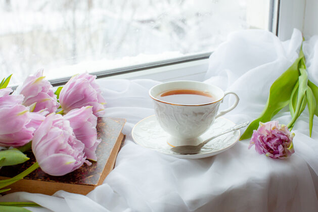 床单一杯茶一本旧书一束郁金香在窗户上刷新3月8日健康