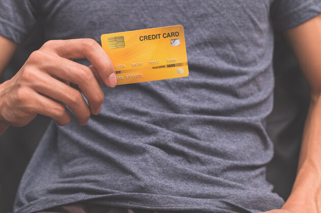 消费者一个手里拿着信用卡的男人借记男人金融