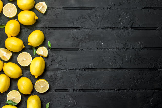 果汁成熟多汁的柠檬放在黑色乡村餐桌上成熟乡村美味
