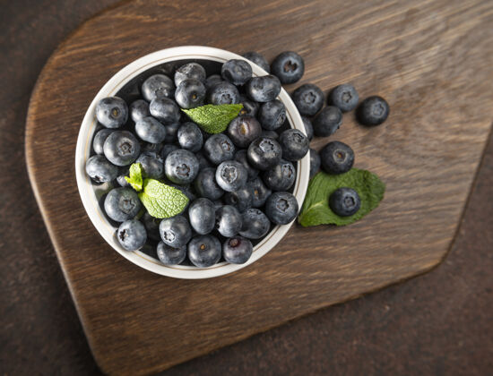 甜味蓝莓放在盘子里木的熟的新鲜多汁的蓝莓健康食物甜点