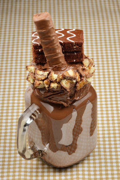 冰巧克力奶昔配巧克力蛋糕 巧克力酱和糖果疯了古怪的食物趋势.copy空间传统的巧克力假日