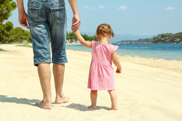 朋友爸爸妈妈牵着小孩的手走在沙滩上老人老人强壮