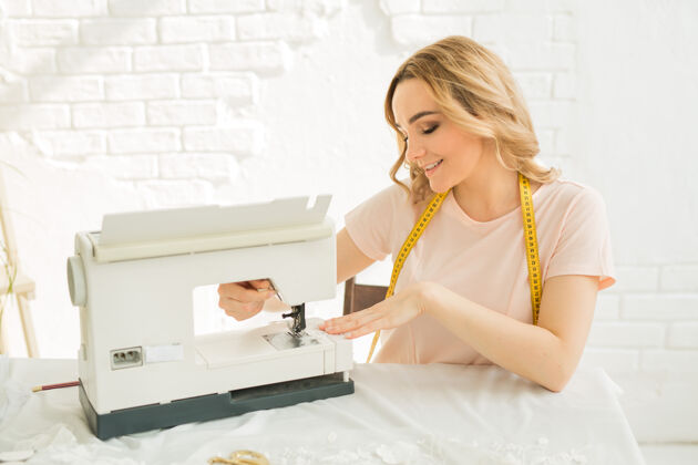 职业一个漂亮的年轻女人在工厂里 桌上摆着一台缝纫机缝纫刺绣爱好