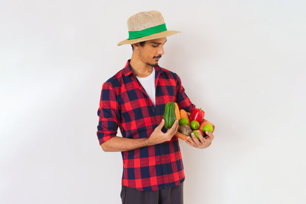 蔬菜一个戴着帽子和手套的黑人农民手里拿着一篮子蔬菜（胡萝卜 柠檬 西红柿 佛手瓜和甜菜） 背景是白色的快乐柠檬欢呼