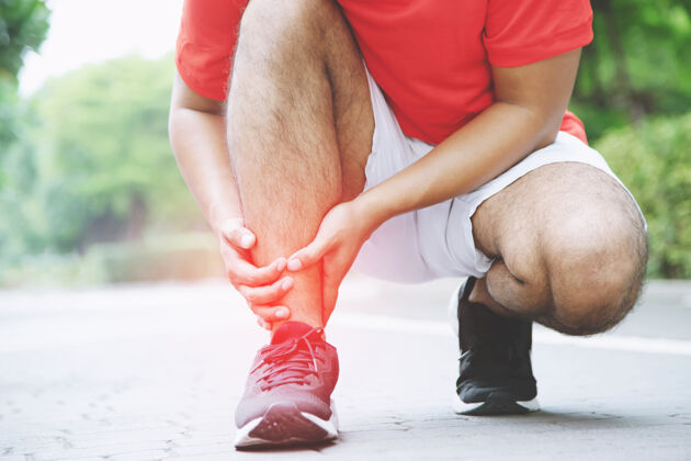 跑步跑步者触碰疼痛扭曲或折断脚踝运动员跑步训练事故 运动跑步时脚踝扭伤导致受伤膝盖还有腿骨疼痛把红色的腿放在你的身上表示疼痛疼痛脚踝户外