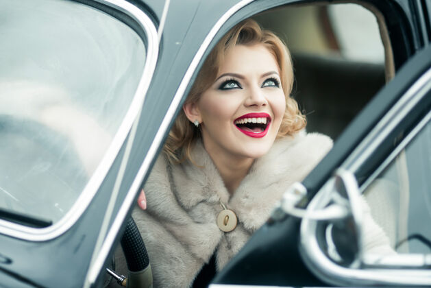 优雅复古微笑的女人在老式汽车里旅行快乐坐在复古汽车上的模特年轻乐趣优雅