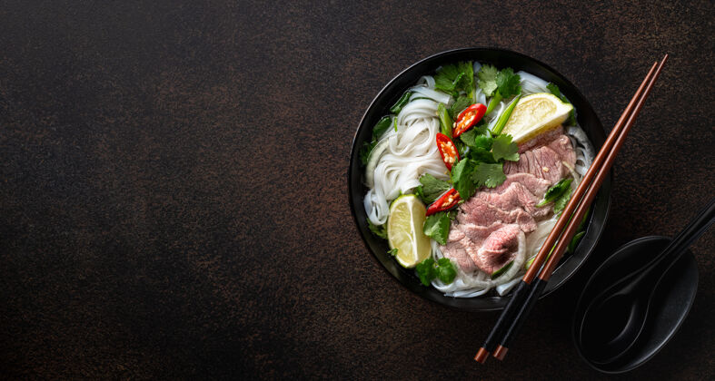 碗Phobo越南汤配牛肉和米粉 背景为深色 顶视图 复制空间菜汤米粉