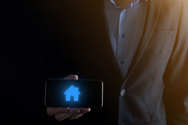购买房地产概念 商人拿着房子icon.house公司在手部财产保险和安全概念.保护人的姿态和房子的象征安全销售保险