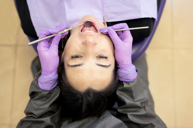 围嘴患者坐在牙科治疗椅上进行牙科治疗的正上方视图肖像牙科室内
