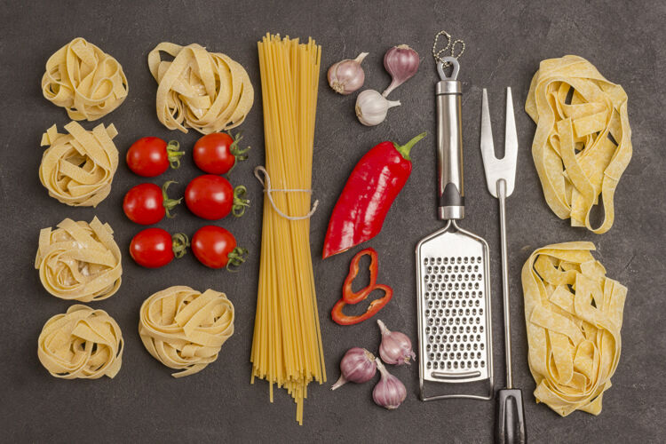 传统各种类型和形状的意大利干面食 有西红柿 红辣椒 大蒜 欧芹还有叉子美食蔬菜有机食品