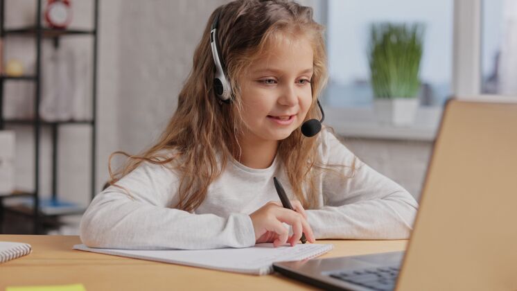 在线教育女生在耳机里有在线上课 和老师视频通话 在家学习用笔记本电脑距离学习之家教育课程学习交流