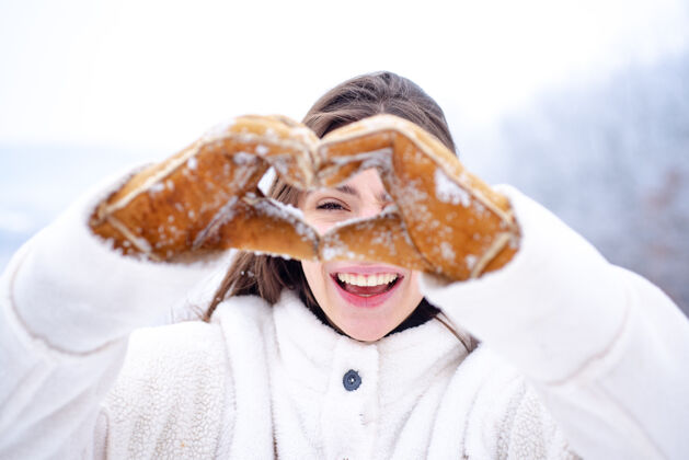 乐趣快乐女人秀心女人手在冬季手套心形符号享受天气户外