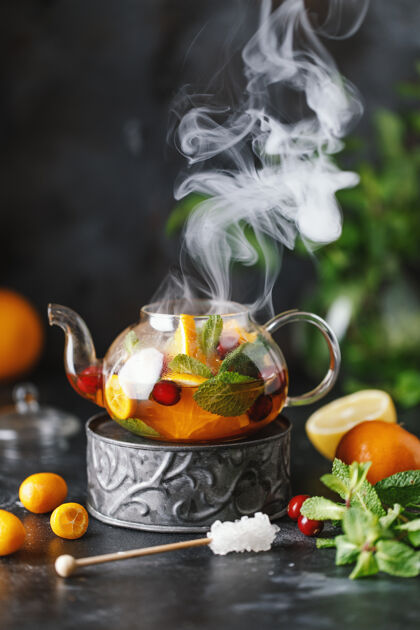 水果水果茶配薄荷 橙子和红莓 背景为深色石头一杯热茶食物茶早餐