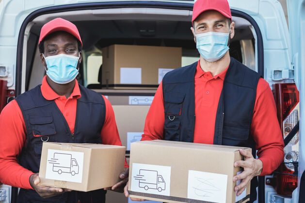 保护在冠状病毒爆发期间 多种族工作人员戴着安全口罩运送箱子-关注脸部送货服务面具