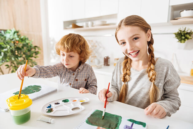 周末创建调色板激情快乐美丽的女孩在画画时用了很多绿色的色调 在家里和弟弟一起尝试新买的颜色人才上午激情