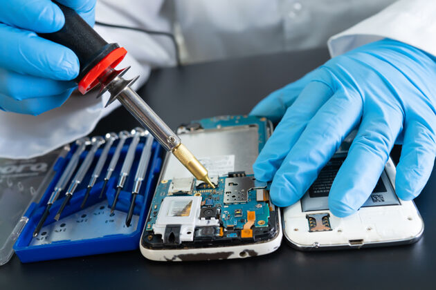 修理技术人员通过焊接修复手机内部铁.集成电路数据 硬件 技术的概念维修加热铁