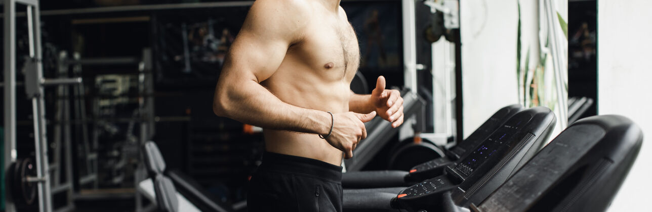 运动员男人在跑步机上的健身房里跑步锻炼 健身和健康的概念生活方式高高质量的照片自信私人教练运动