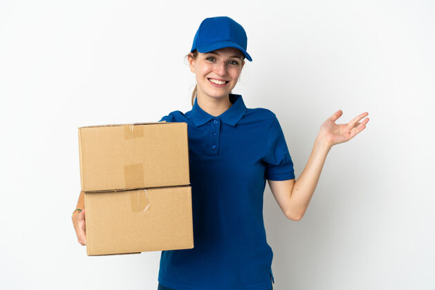 手被隔离在白色背景上的年轻女送货员向侧面伸出双手 欢迎前来盒子送货成人