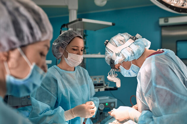 制服手术室里的女外科医生一队现代医生在外科手术中与病人搏斗癌症重建癌症后的整形手术外科设备剧院
