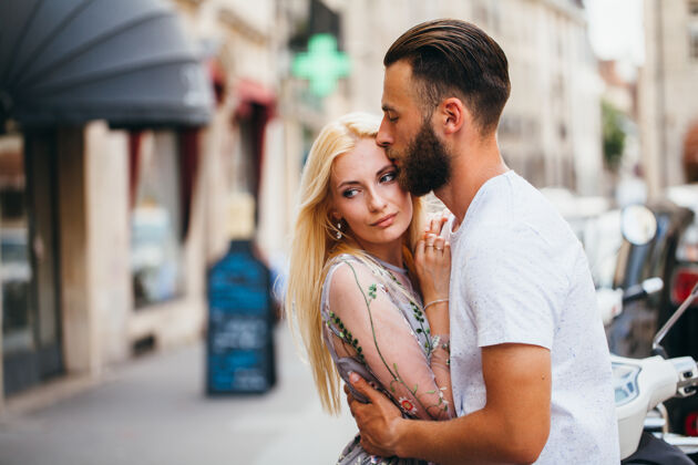 户外金发女孩和时髦帅哥胡子拥抱和亲吻在城市街道上成人男人关系