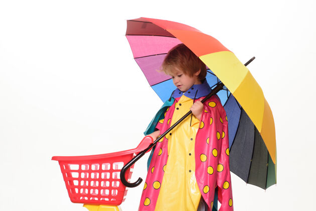 活动带着彩虹色雨伞的小男孩被隔离在白色的墙上天气树叶十一月