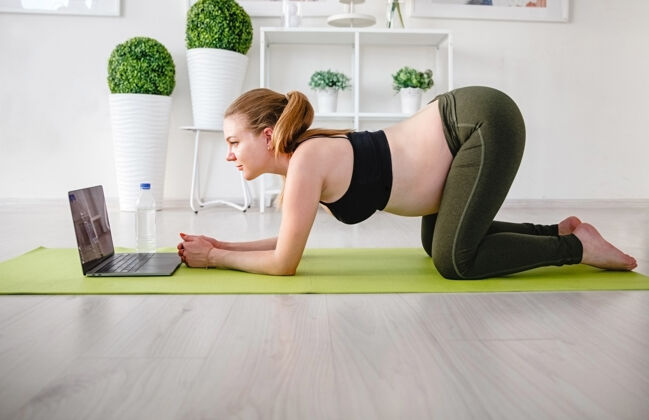 锻炼年轻的金发孕妇在家里做运动垫高高质量的照片金发健康垫子