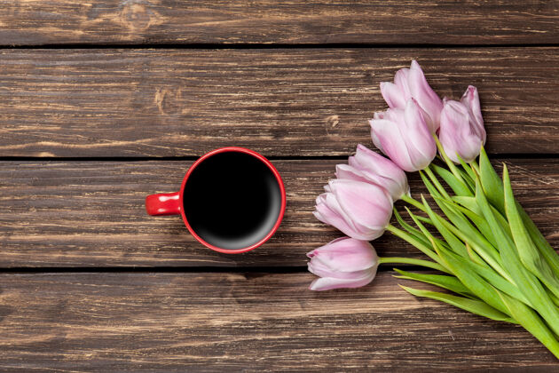 饮料一杯咖啡和一束郁金香放在木头表面咖啡鲜花郁金香