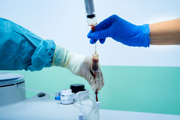 治疗特写实验室助理的手拿着红血袋和注射器在血库单位实验室袋子健康护理