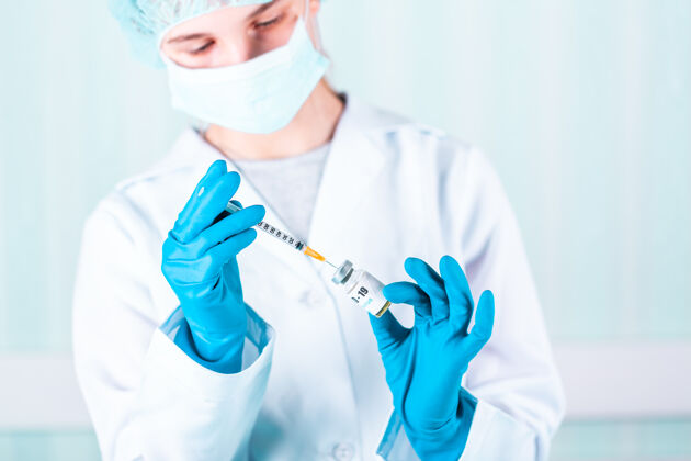 预防女医生或护士穿着制服 戴着手套 戴着口罩 在实验室里拿着带有冠状病毒疫苗标签的药瓶疫苗瓶研究药品护理