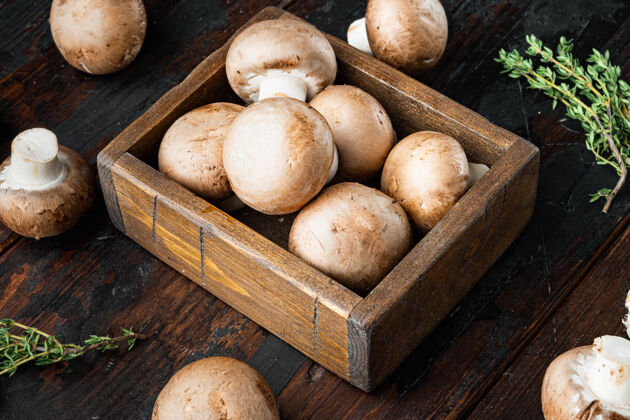 生的棕色香菇套装 放在旧的深色木桌上美味美食真菌