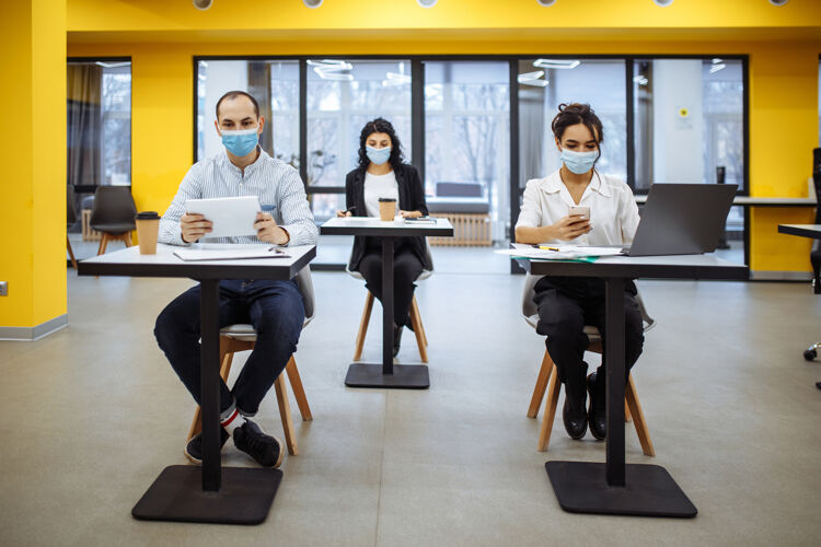 商业女人三位同事在办公室里一起工作 戴着医用口罩保持着社会距离疾病笔记本电脑人
