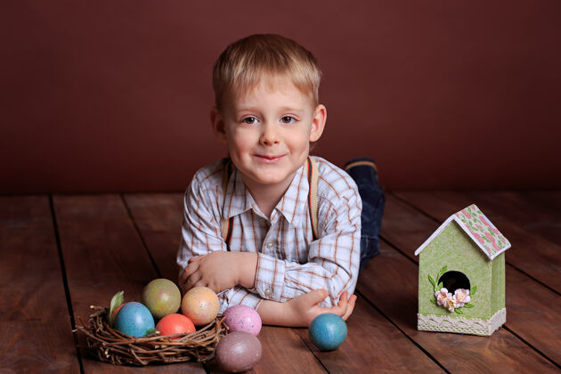 可爱复活节小男孩玩具五颜六色柳条窝里的复活节彩蛋 鸟的鸟舍鸟舍孩子彩色