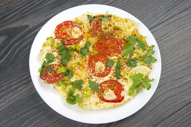 蔬菜在木桌上的白色盘子里放着香草和蔬菜的煎蛋卷美味厨房烘焙