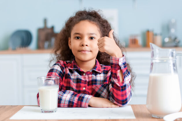 牛奶厨房里有牛奶的非洲裔小女孩拇指钙产品