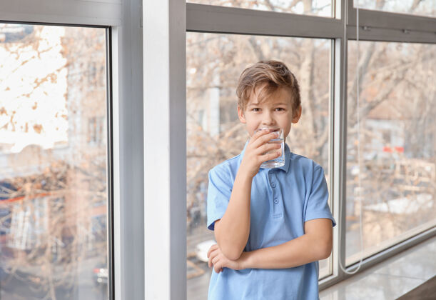 矿物质可爱的小男孩在窗户边喝水清洁健康房子