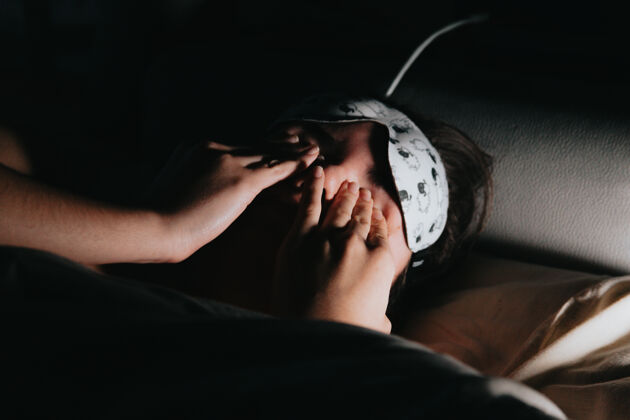 梦年轻的女人在床上戴着口罩睡不着的时候碰了碰他的眼睛午睡坐垫年轻