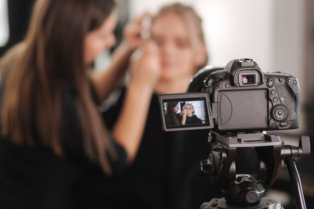 模特女人在工作室为漂亮的金发女人化妆视频博客摄影年轻人