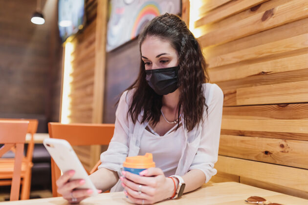 工作一个戴着病毒面具的年轻女子咖啡城市在隔离高质量流感顾客咖啡馆