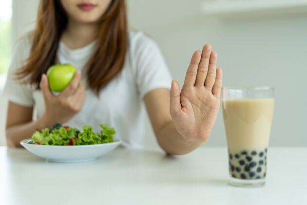 糖尿病健康女性不吃珍珠奶茶 选择苹果和沙拉蔬菜女人拒绝食物和饮料 但吃健康的维生素食品.概念饮食健康膳食碳水化合物甜食