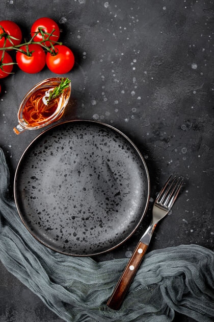 营养空盘子 叉子 西红柿和油在肉汁船上的黑色背景俯视图盘子复制空间餐具