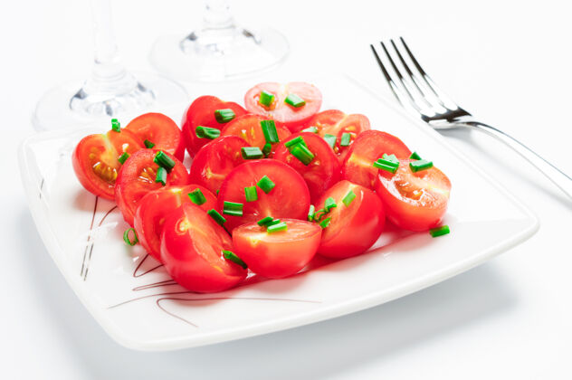 盘子用绿色装饰的樱桃西红柿洋葱一个白色的方盘子上碗蔬菜
