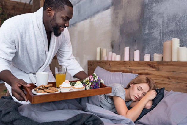 关系显示爱体贴年轻的非洲男人在妻子睡觉的时候给她送早餐 一起享受周末周末休闲赛车